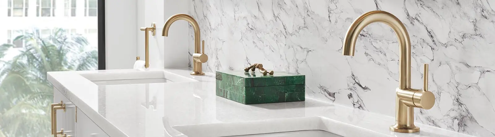 Bathroom vanity with marble backdrop and polisted brass faucets