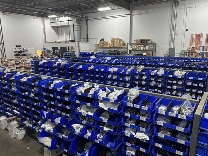 Blue bins full of plumbing supplies and fixtures at Weinstein Reading
